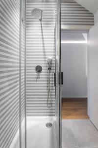 y baño con ducha y puerta de cristal. en Vista Lisboa Guest Apartments, en Almada