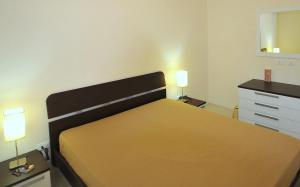 1 dormitorio con cama, tocador y espejo en Villa Elen, en Marsala
