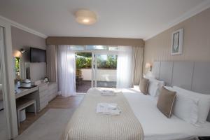 a hotel room with a large bed and a bathroom at La Place Country Cottages in Saint Aubin +28 photos