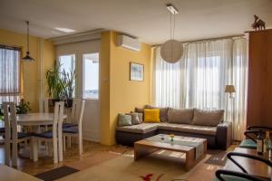 een woonkamer met een bank en een tafel bij Sunny Apartment in Belgrado