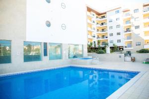 a swimming pool in front of a apartment building at Lagos Central Wellness in Lagos