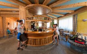 two men standing at a bar in a restaurant at Hotel Tourist in Valtournenche