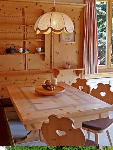 una mesa de madera y sillas en una habitación de madera en Chesa Rosatsch en Surlej