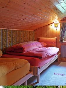 1 dormitorio con 2 camas en una pared de madera en Chesa Rosatsch en Surlej