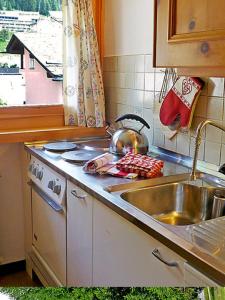 um balcão de cozinha com um lavatório e um fogão em Chesa Rosatsch em Surlej