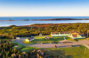 an aerial view of a large house on a hill next to the water at Auberge la Salicorne et Escapades - Adventure Resort in Grande-Entrée