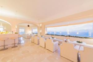 a restaurant with white chairs and a bar at Grand Hotel Aminta in Sorrento