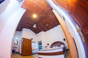 Cette chambre comprend un lit et un plafond en bois. dans l'établissement Shadow Surf Bay, à Tangalle