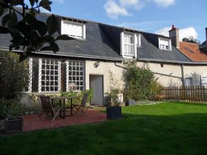 a house with a patio and a table in the yard at Le Clos Audy près de Chambord in Huisseau-sur-Cosson