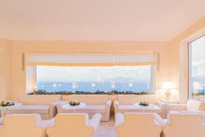 a living room with couches and a large window at Grand Hotel Aminta in Sorrento
