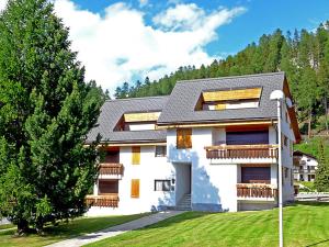 a large white house with a tree in front of it at Chesa Rosatsch in Surlej