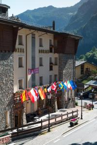 a building with many flags on the side of it at Hotel Tourist in Valtournenche