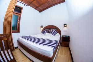 a bedroom with a bed in a room with a window at Shadow Surf Bay in Tangalle