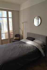 a bedroom with a large bed and a mirror at MAGNIFIQUE APPARTEMENT JEAN MEDECIN/NOTRE DAME in Nice