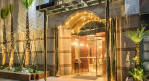 an entrance to a building with palm trees at IP City Hotel Osaka - Imperial Palace Group in Osaka