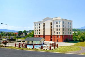 un gran edificio con una pequeña casa delante en River Crossing 401, en Pigeon Forge