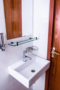 ein Badezimmer mit einem weißen Waschbecken und einem Spiegel in der Unterkunft Golden Zaan Hotel, Zaandam-Amsterdam in Zaandam