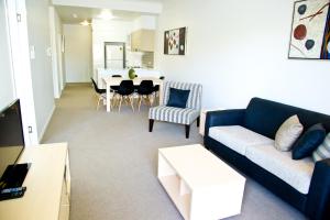 a living room with a couch and a dining room at Jacana Apartments in Townsville