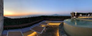 a swimming pool with chairs and a sunset in the background at Grand Hotel Aminta in Sorrento