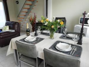 a dining room table with a vase of flowers on it at The Mill 2380 in Ravels
