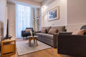 ein Wohnzimmer mit Sofa und Tisch in der Unterkunft Upscale & Modern 2BDR Apartment in Lissabon