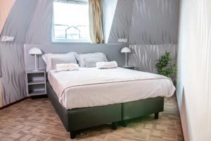 een slaapkamer met een groot bed met 2 kussens bij Golden Zaan Hotel, Zaandam-Amsterdam in Zaandam