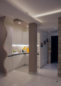 una cucina con armadi bianchi e una colonna in una stanza di Giglio Luxury Apartment - Chroma Italy a Roma