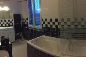 a bathroom with a bath tub and a sink at La maison d'amis in Auneuil +17 photos