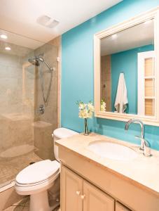 a bathroom with a toilet and a sink and a shower at Beach Living at Island Pine Villas (BLV) in George Town