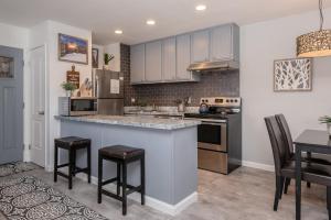 a kitchen with white cabinets and a bar with stools at San Sierra 2 in Mammoth Lakes
