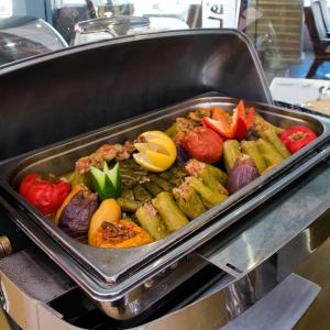 a pan filled with vegetables on a grill at PETRA Cabin Dorms Hostel in Wadi Musa