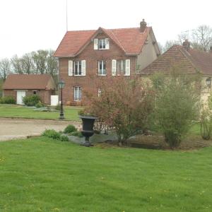 una casa con un baño de aves en el patio en La maison d'amis, en Auneuil