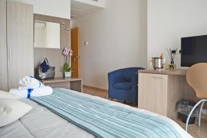 a hotel room with a bed and a blue chair at Perla Hotel e Garden - Free Parking and Pool - Open area with Beautiful view of the Landscape in Capaccio-Paestum