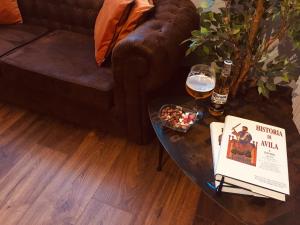 - Mesa de centro con copa de vino y bebida en Panorama Ático, en Ávila