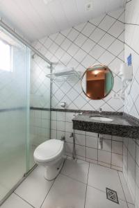 a bathroom with a toilet and a sink and a mirror at Hotel GAPH Maringa - Economico Mini Resort in Maringá