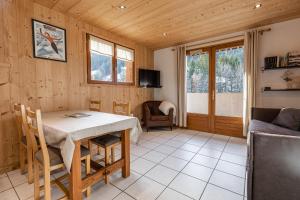 a dining room with a table and a couch at La Duche 101 in Le Grand-Bornand