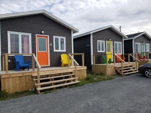 a row of houses with colorful chairs on a deck at Burnt Cape Cabins in Raleigh