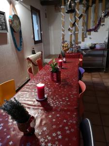 a long red table with candles on top of it at Au Nid de Tillé in Tillé