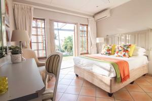 Schlafzimmer mit einem Bett, einem Tisch und Stühlen in der Unterkunft 15 Oyster Crescent in Durban