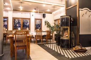 a restaurant with a fireplace and a table and chairs at Hotel Promyk Wellness & Spa in Karpacz