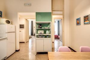 eine Küche mit einem weißen Kühlschrank und einem Tisch in der Unterkunft Borghese Green in Rom