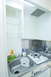 uma cozinha com um fogão e um lavatório em Cozy house 8, free wifi a rented electric bicycle em Quioto