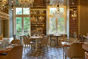 a dining room with tables and chairs and windows at My Story Hotel Rossio in Lisbon