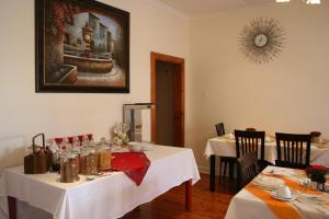 a dining room with two tables with white tablecloths at Ocean Dreams B&B in Gonubie