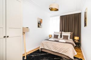 a bedroom with a bed and a large window at Main Square Apartments by LoftAffair in Krakow