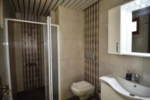 een badkamer met een douche, een toilet en een wastafel bij Balalayka Butik Otel in Mugla