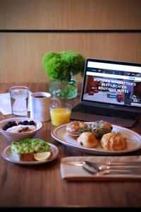 a table with plates of food and a laptop computer at The Pearl Hotel in New York