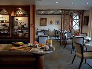 a restaurant with a table with food on it at Hotel Les Remparts in Kaysersberg