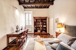 ローマにあるBorgo Pio Passetto Papaleのデスク、ベッド、テーブルが備わる客室です。