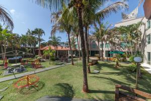a park with a playground and a palm tree at Hotel GAPH Maringa - Economico Mini Resort in Maringá